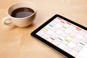 a cup of coffee and a calendar on a screen, symbolizing time management