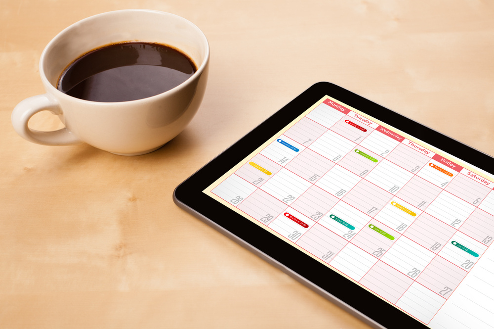 a cup of coffee and a calendar on a screen, symbolizing time management